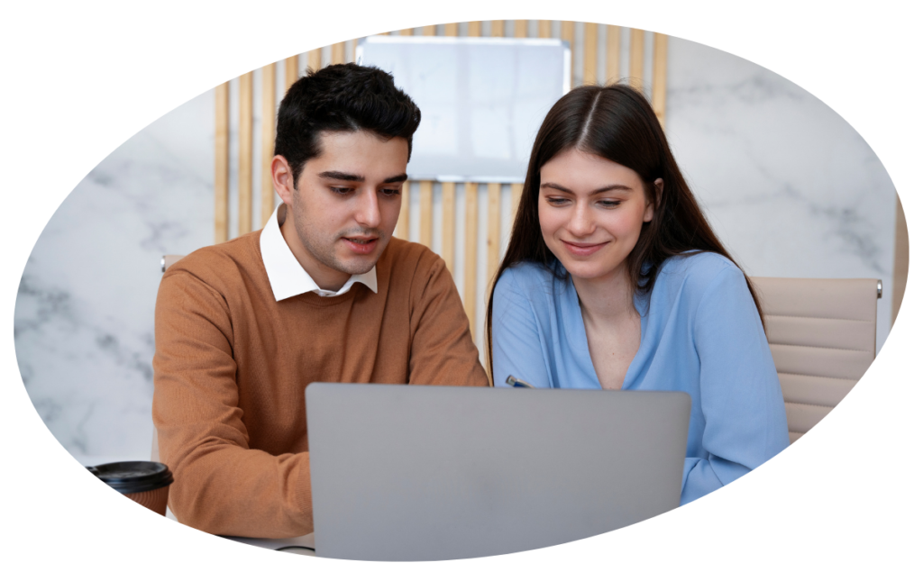 one girl and boy smiling at looking laptop